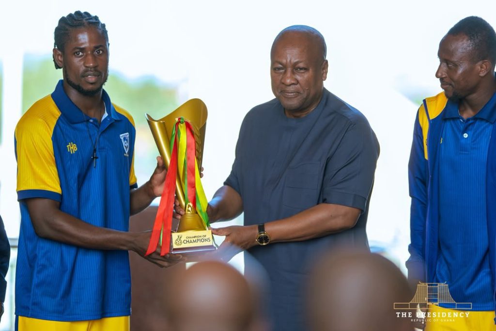 Medeama presenting their tropphy to the President
